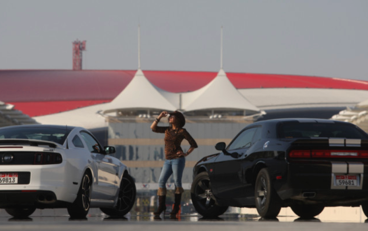 Art directed motorsport shoot at Yas Marina Circuit, Abu Dhabi — two muscle cars flanking a model